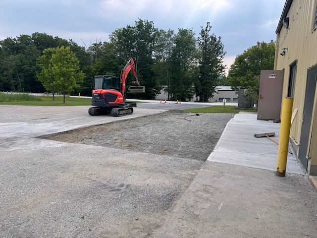 Exterior of 310 Innovation Drive with an excavator and freshly poured concrete apron near the entrance
